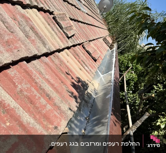 גג רעפים אדום עם מרזב מתכת בצד